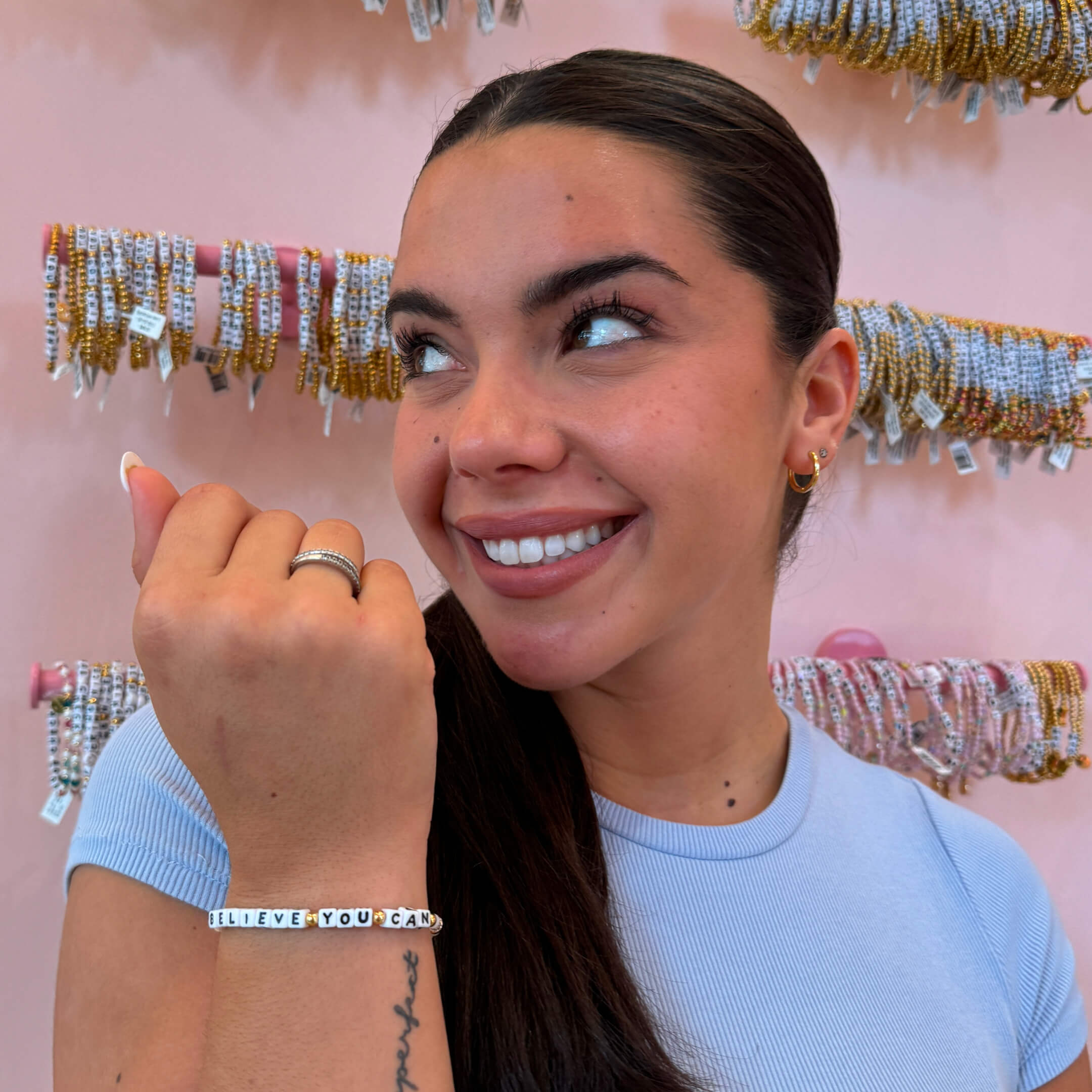 Anastasia Pagonis wearing her Believe You Can Little Words Project Bracelet in an LWP Store